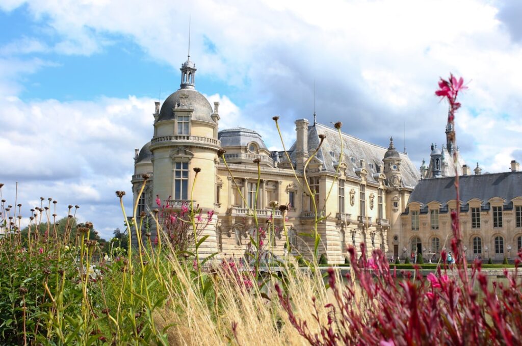 Grand chateau with blooming flowers and dramatic clouds