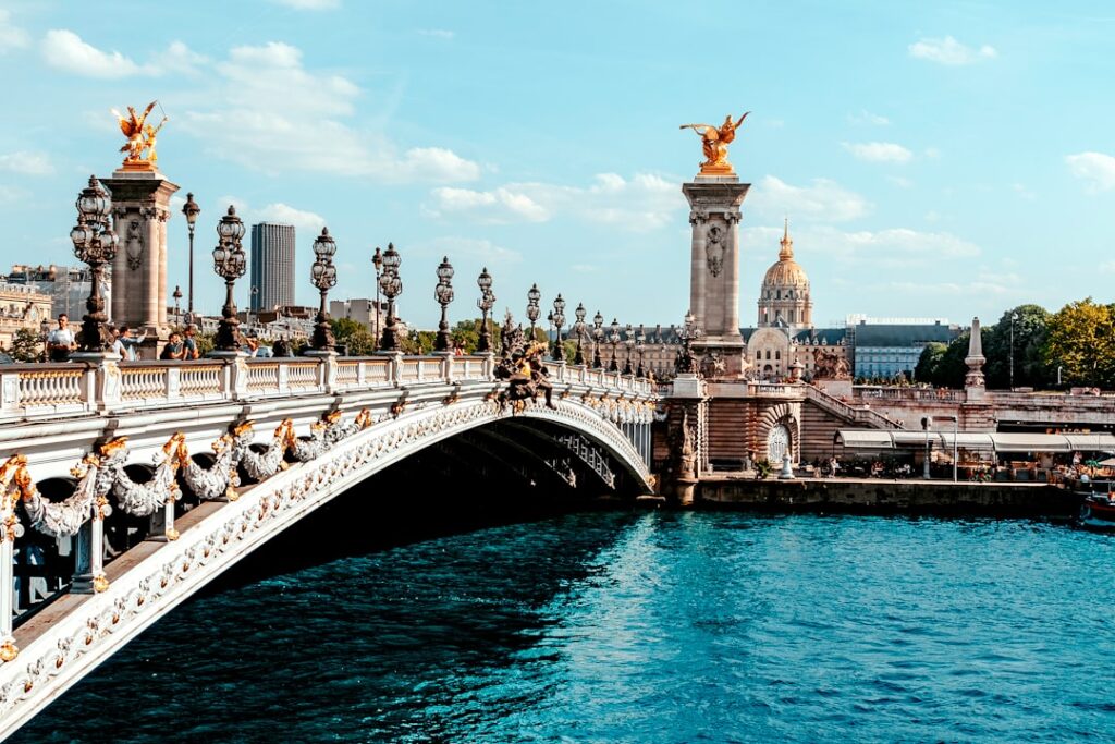 a bridge over a body of water with a statue on top