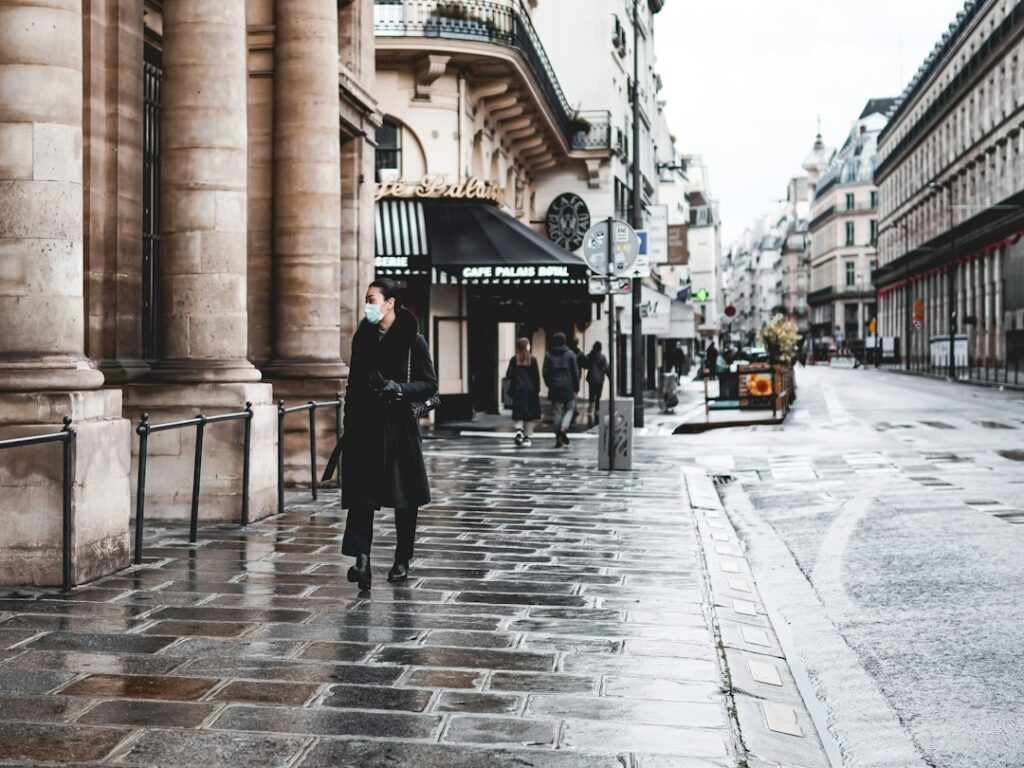 man in black thobe standing on sidewalk during daytime