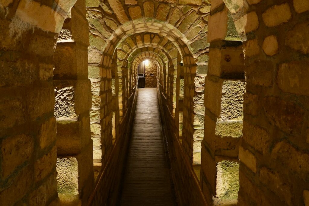 Stone archway tunnel leads into the distance