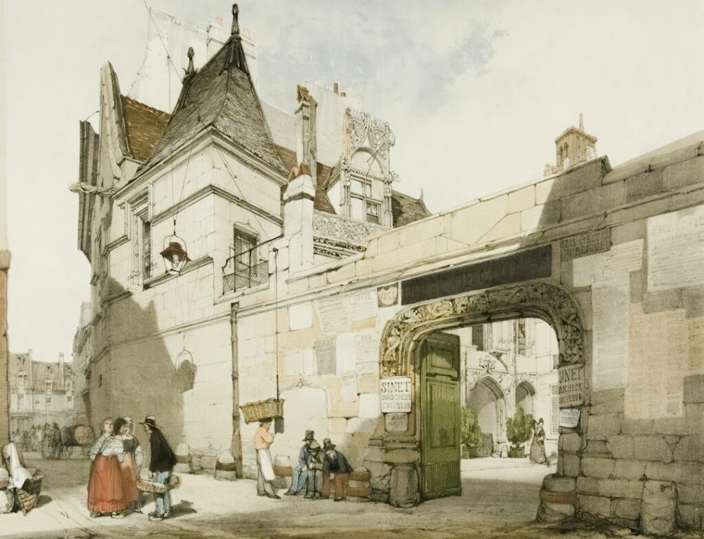 People gathered near an ornate stone archway and building
